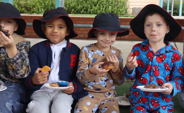 Primary students eating cakes