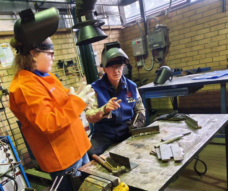 Student listening to teacher at Welding course