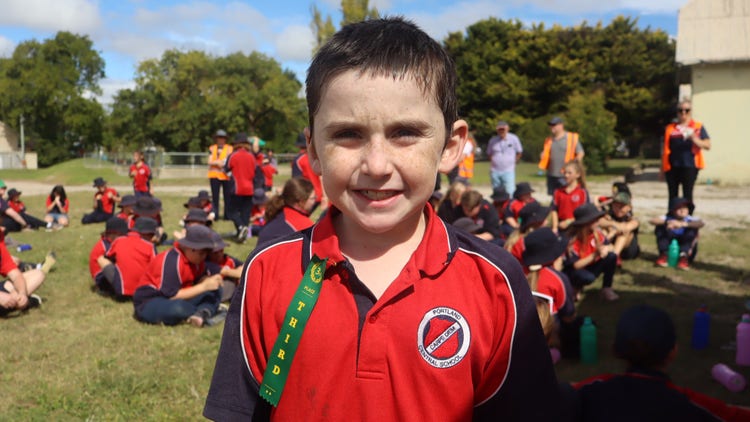A student at Cross Country with a third place ribbon.